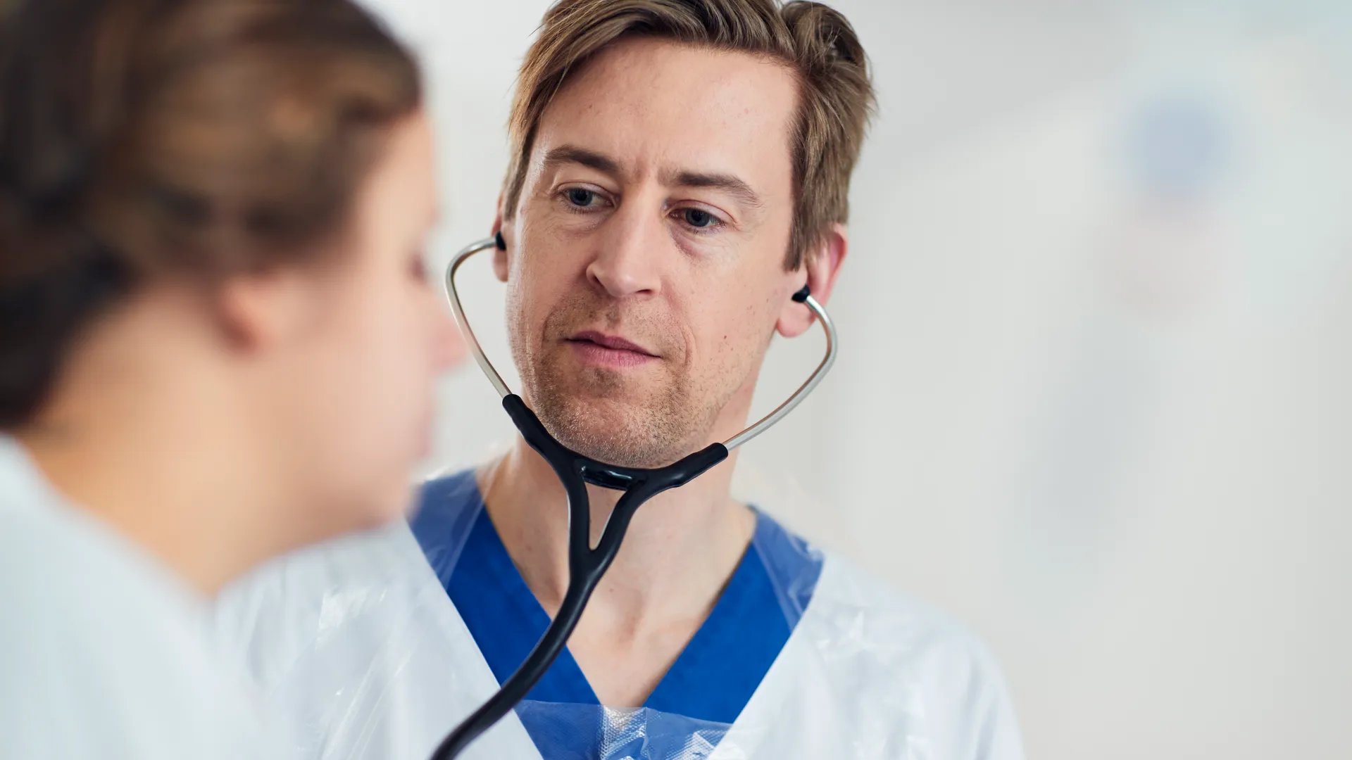 En läkare som pratar med en patient med ett stetoskop.